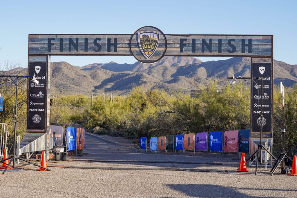 finish line arch with mountains and cacti in distance