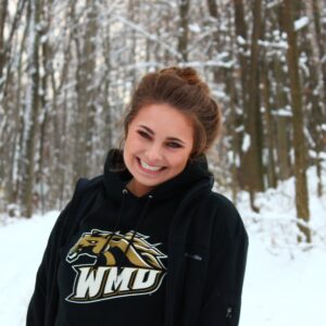 picture of Rachel smiling with snowy woods in the background