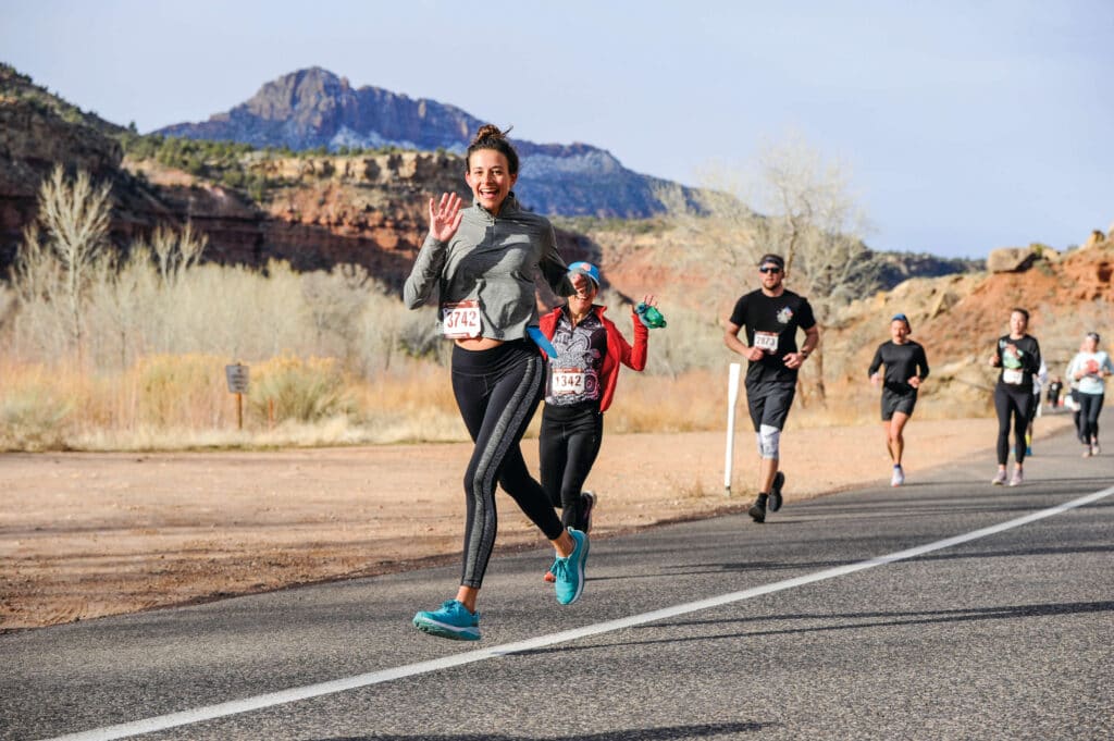 Woman smiling as she runs the Zion half Marathon