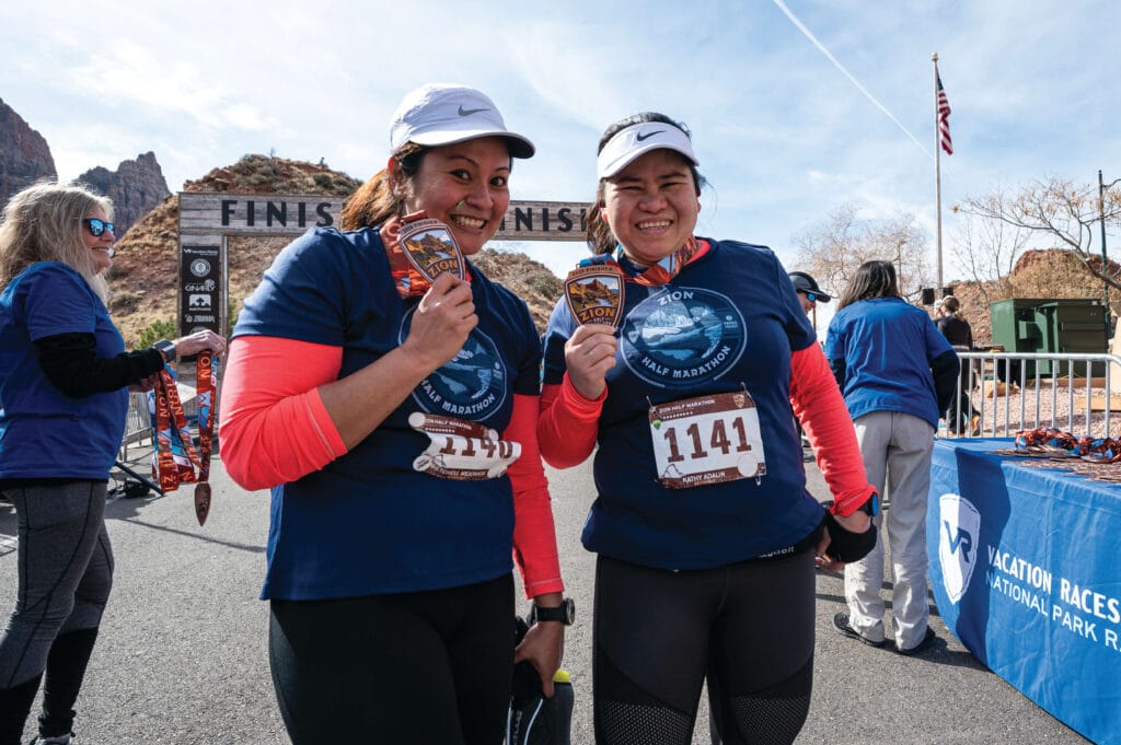 two Zion runners holding up their medals
