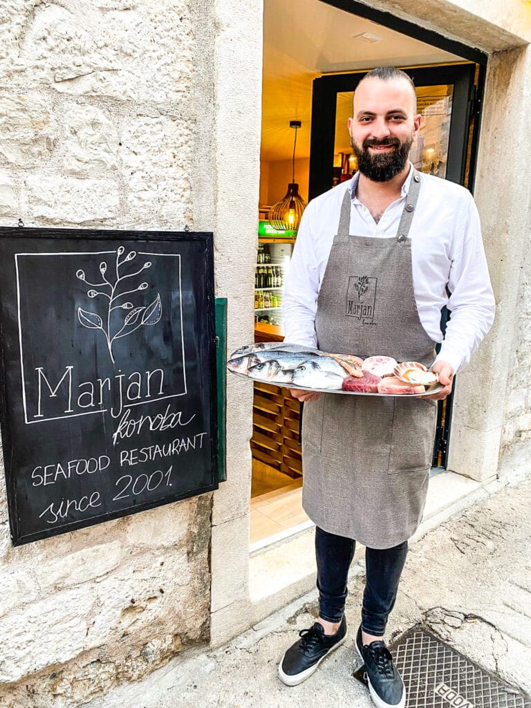A local chef holding a plate of seafood