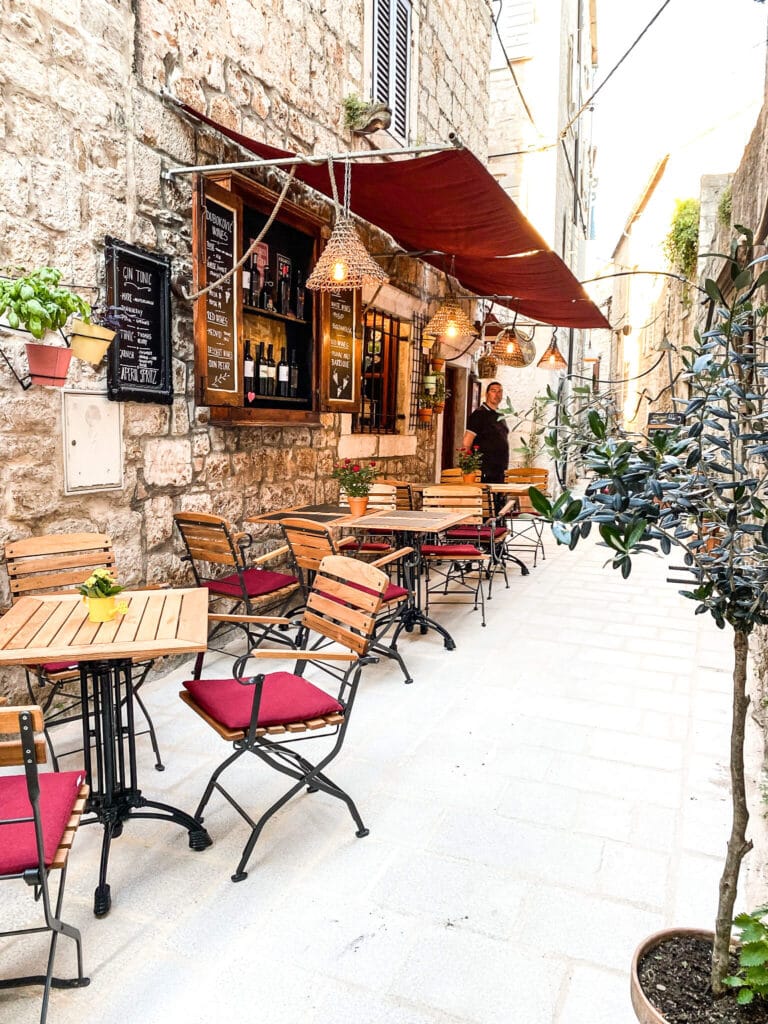 An outdoor restaurant in a cobblestone alleyway