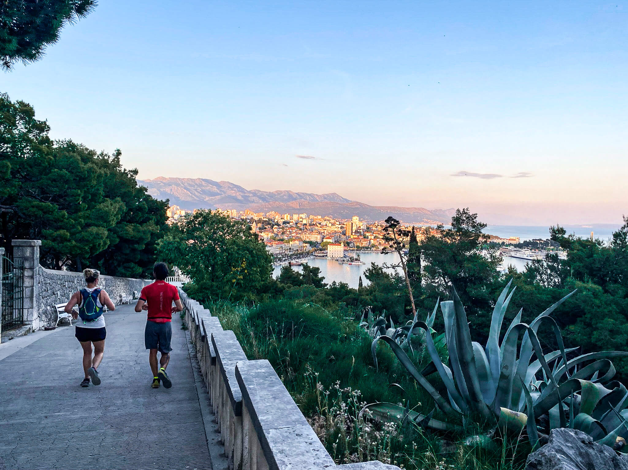 Croatia-Split - 10 of 93 Two runners descending a walkway with a sunset view of Spli in front of them