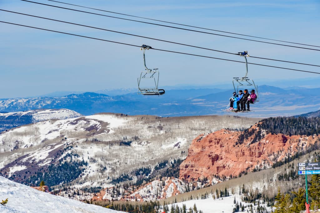 Skiers riding a chair lift at brian head resort