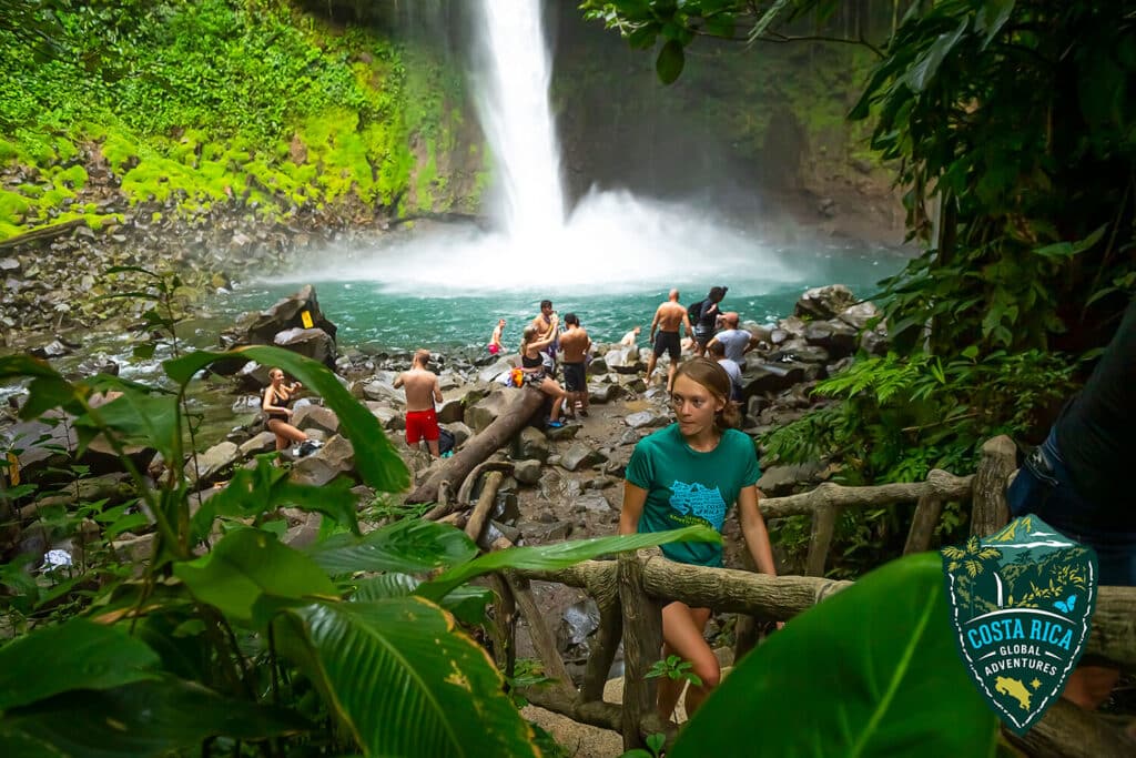 People bathing and hanging out at the bottom of a waterfall