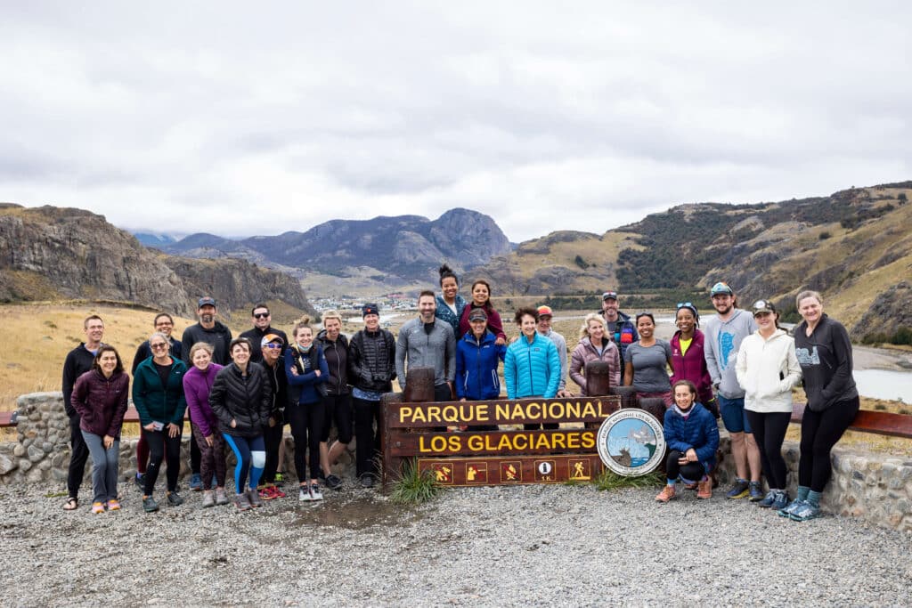 group of runners posing by the Los Glaciares National Park sign