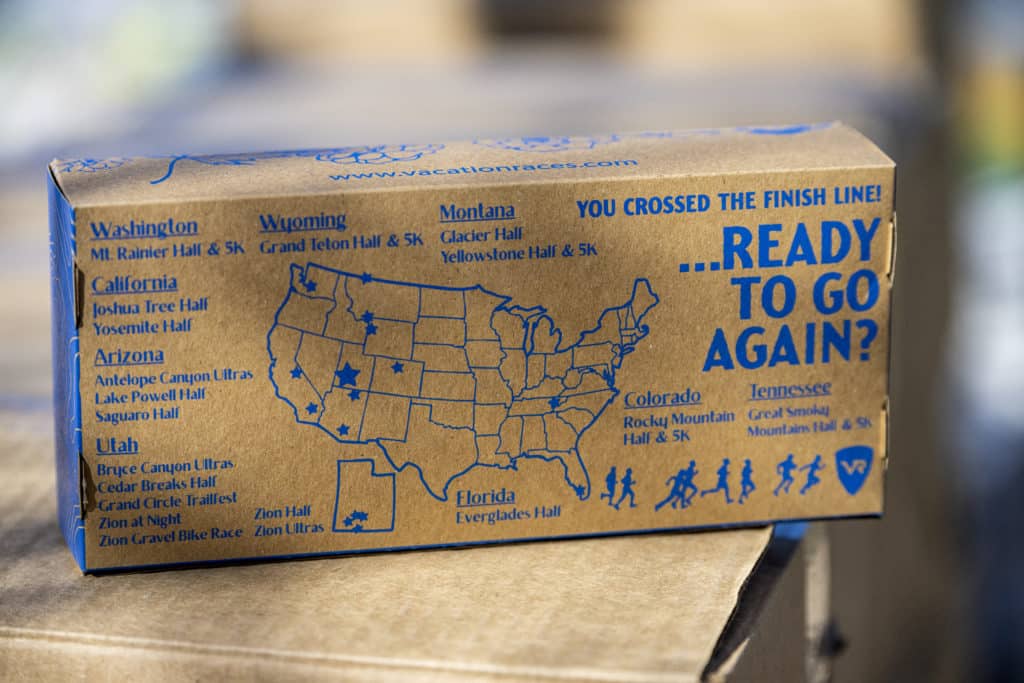A finisher boxes sits full of healthy recovery snacks for runners to cross their Vacation Races finish line