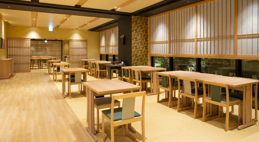 A brightly lit hotel dining area with bamboo furniture