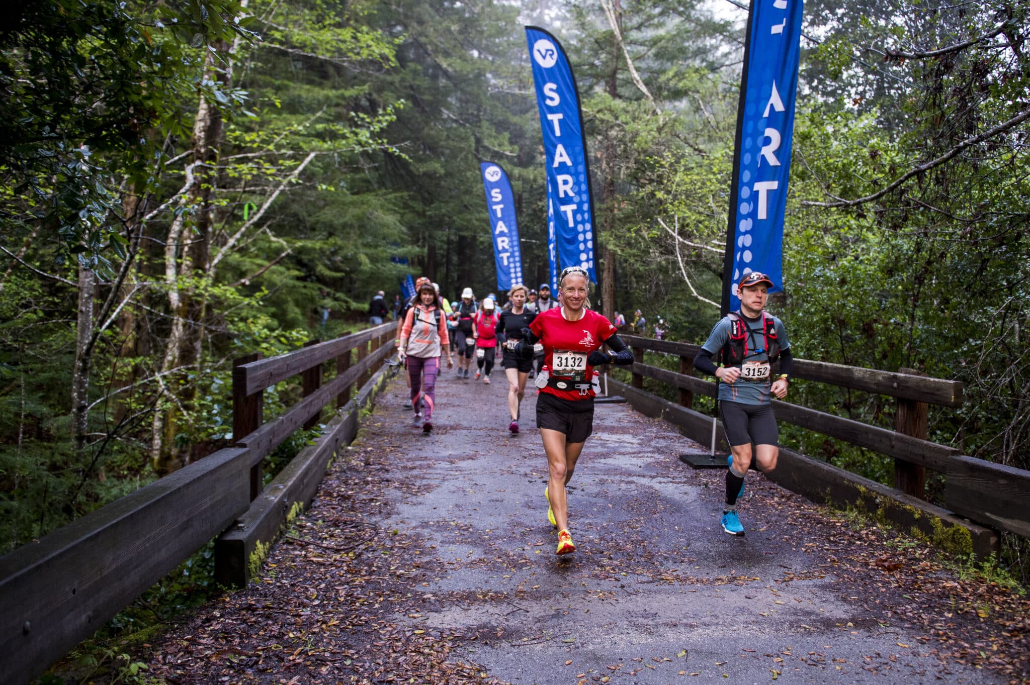 Vacation Races runners start their race running through the dense pine trees and over a wooden bridge