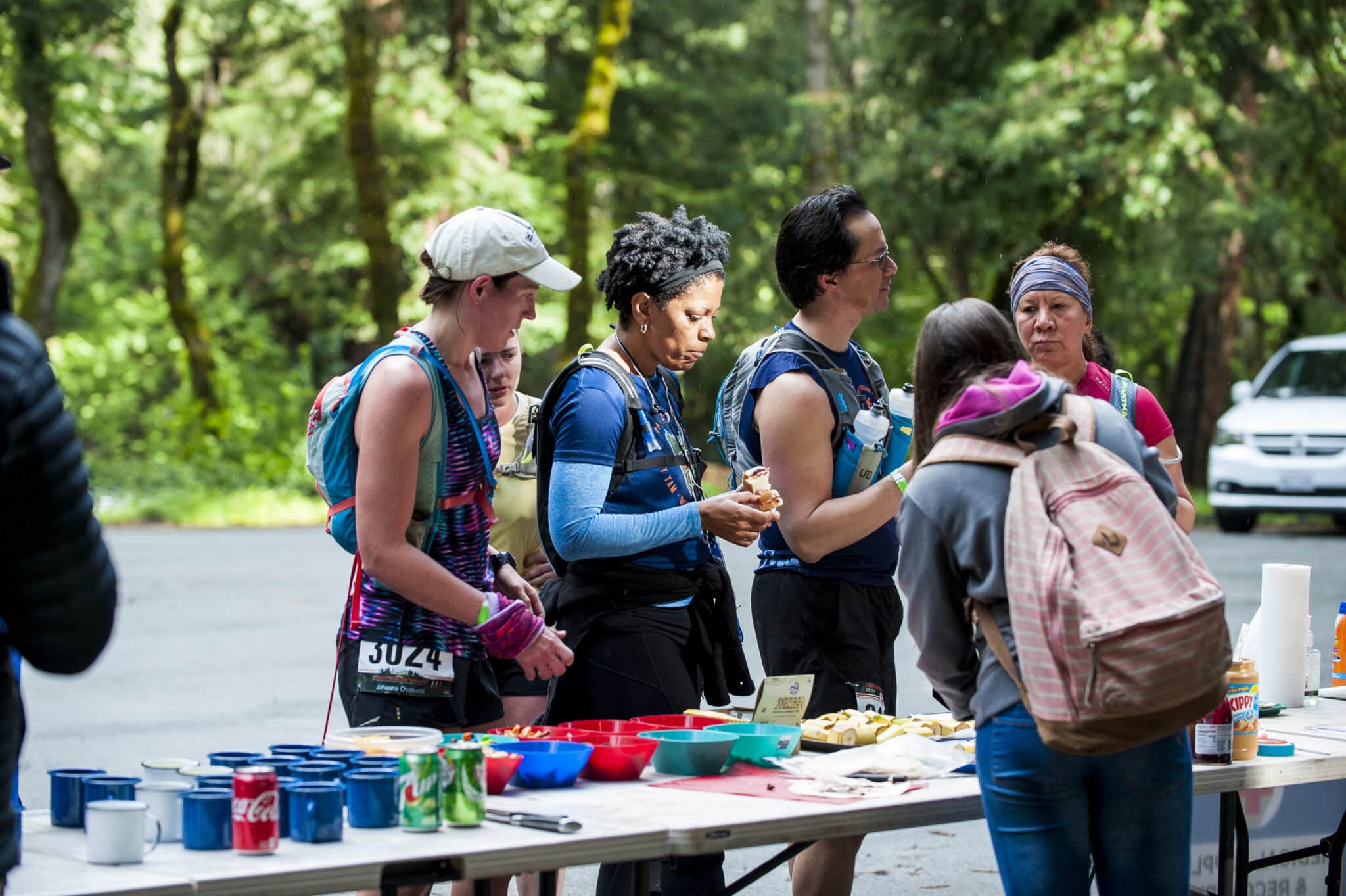 Vacation Races runners break at an aid station to refuel during the Coastal Redwoods Trailfest