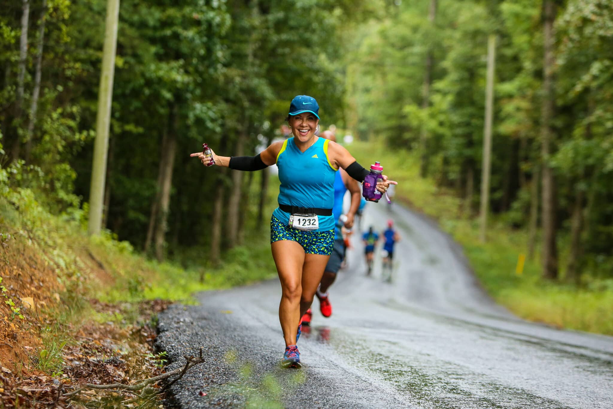 A woman grins and poses for the camera as she sprints towards the Vacation RacesShenandoah Half Marathon finish line