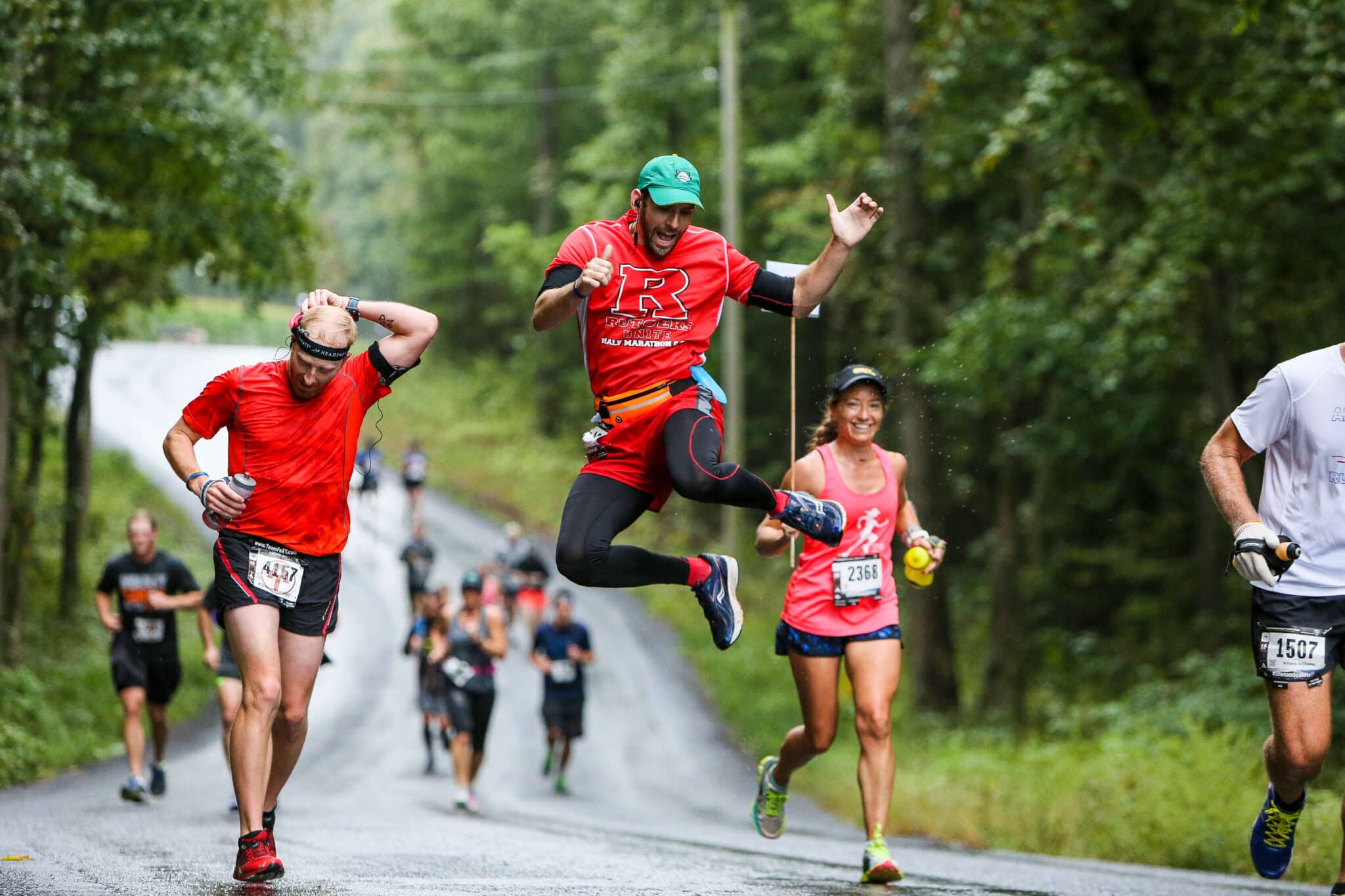 A group of runners jump, smile, and pose ont he Vacation Races Shenandoah Half Marathon course
