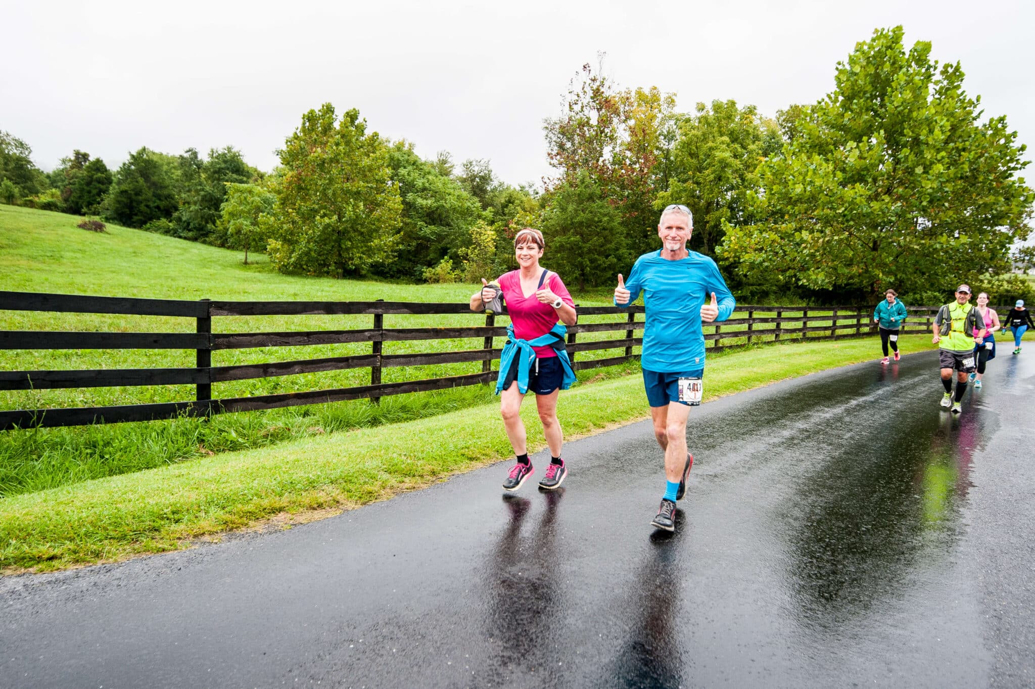 Two Vacation Races runners smiling as they jog down a wide paved road at Shenandoah Half Marathon