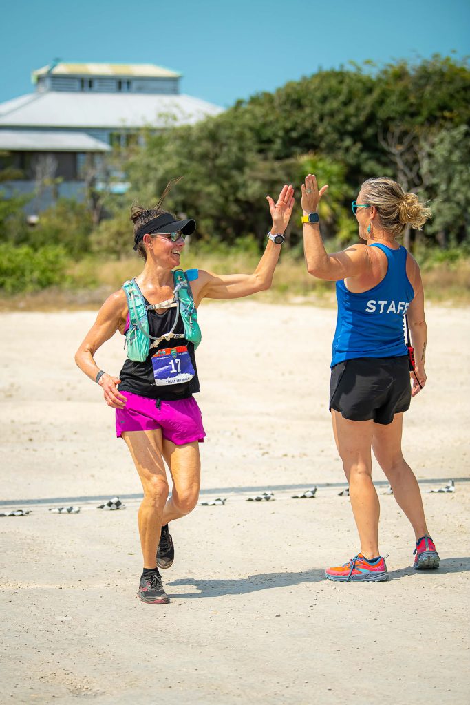 Staff member Cherie high fives a runner as they cross the finish line in Belize