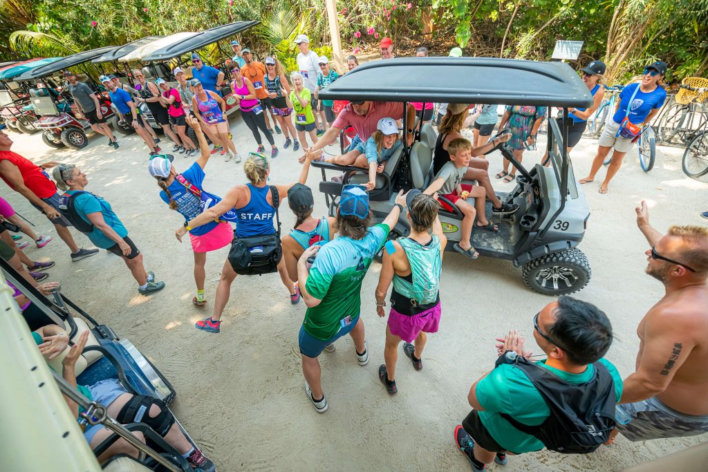 Runners high five and bring high energy to the startbline at their Global Adventures Belize runners pose at the start line of their all-inclusive running trip