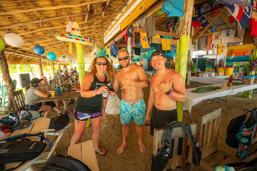 Three runners enjoy a break in the beach tiki hut after a trail run on their Global Adventures Belize runners pose at the start line of their all-inclusive running trip in Belize