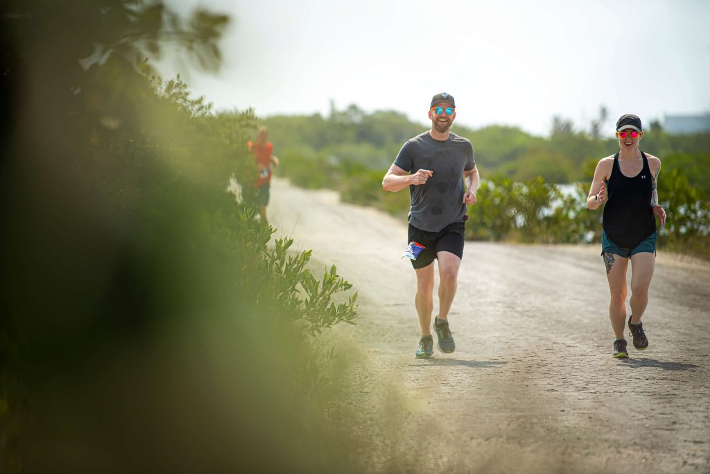 Runners enjoy the Belize sun as they round a bend on their all-inclusive running trip