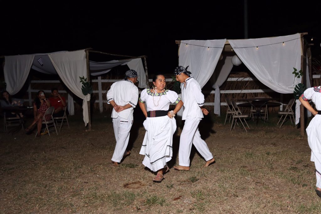 Local dancers perform in white dress at a dinner time excursion on the Belize Global Adventures Belize runners pose at the start line of their all-inclusive running trip