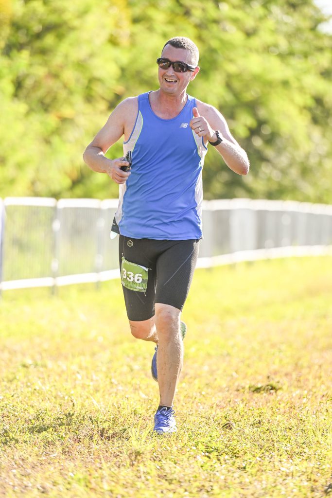 The sun streams on a Vacation Races runner while they pose for the camera