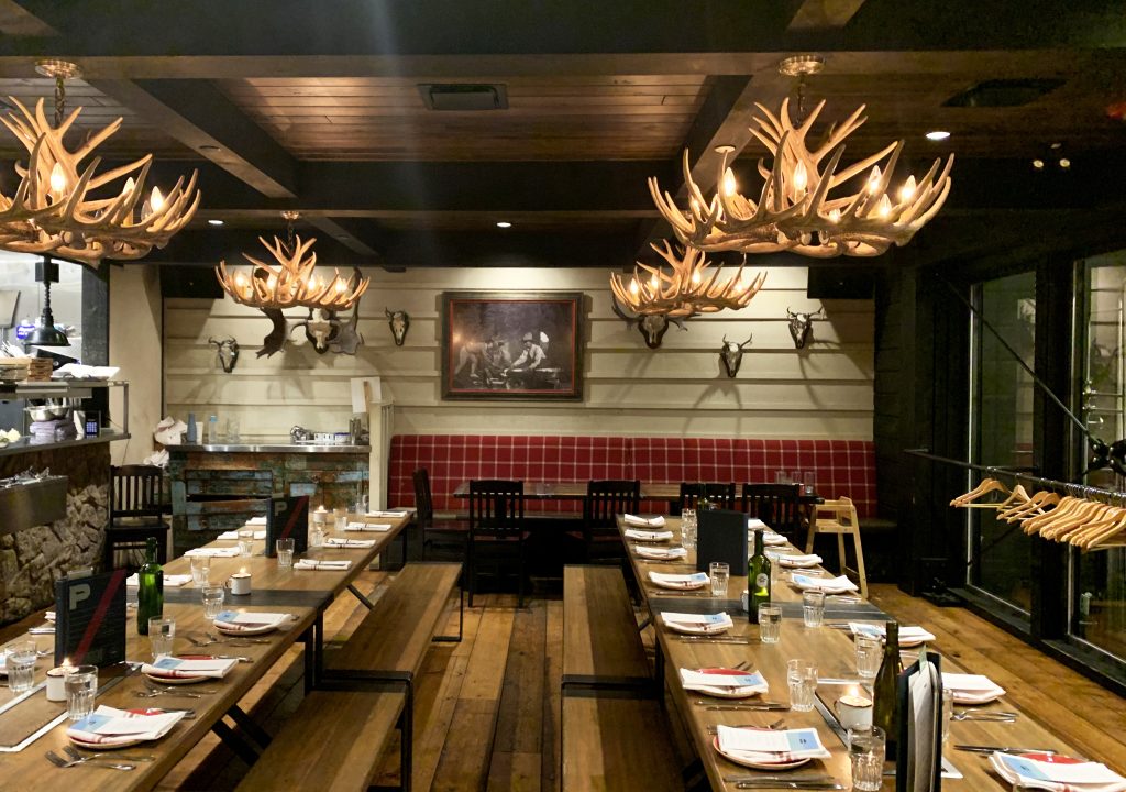 A rustic and cozy restaurant with tables set for Vacation races adventurers