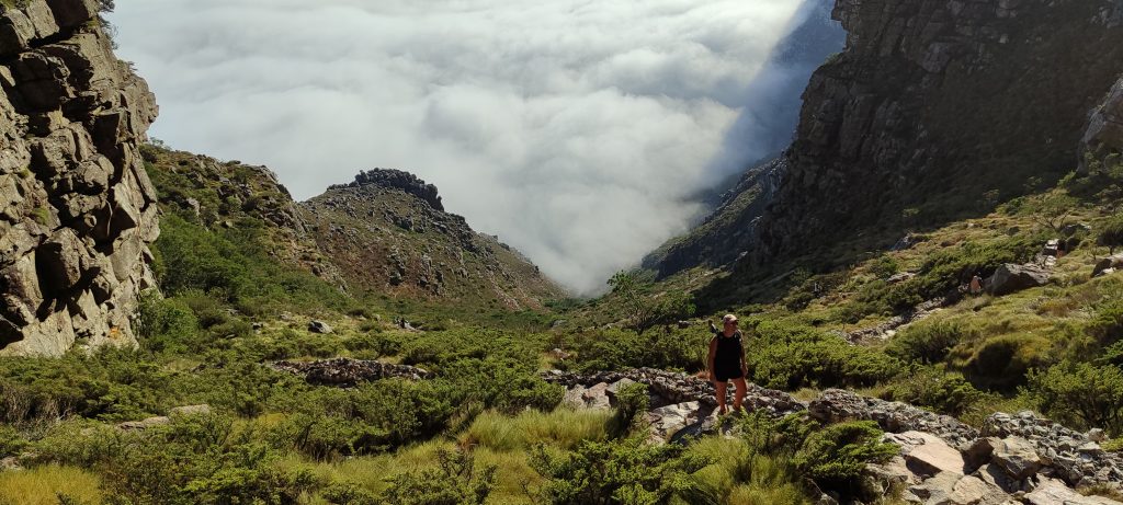 A solo hiker rises above the cloud level on their hike to Table Mountain in South Africa