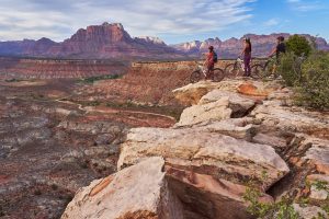 Mountain bikers pause to look out over the red sandstone cliffs and valleys of Zion National Park